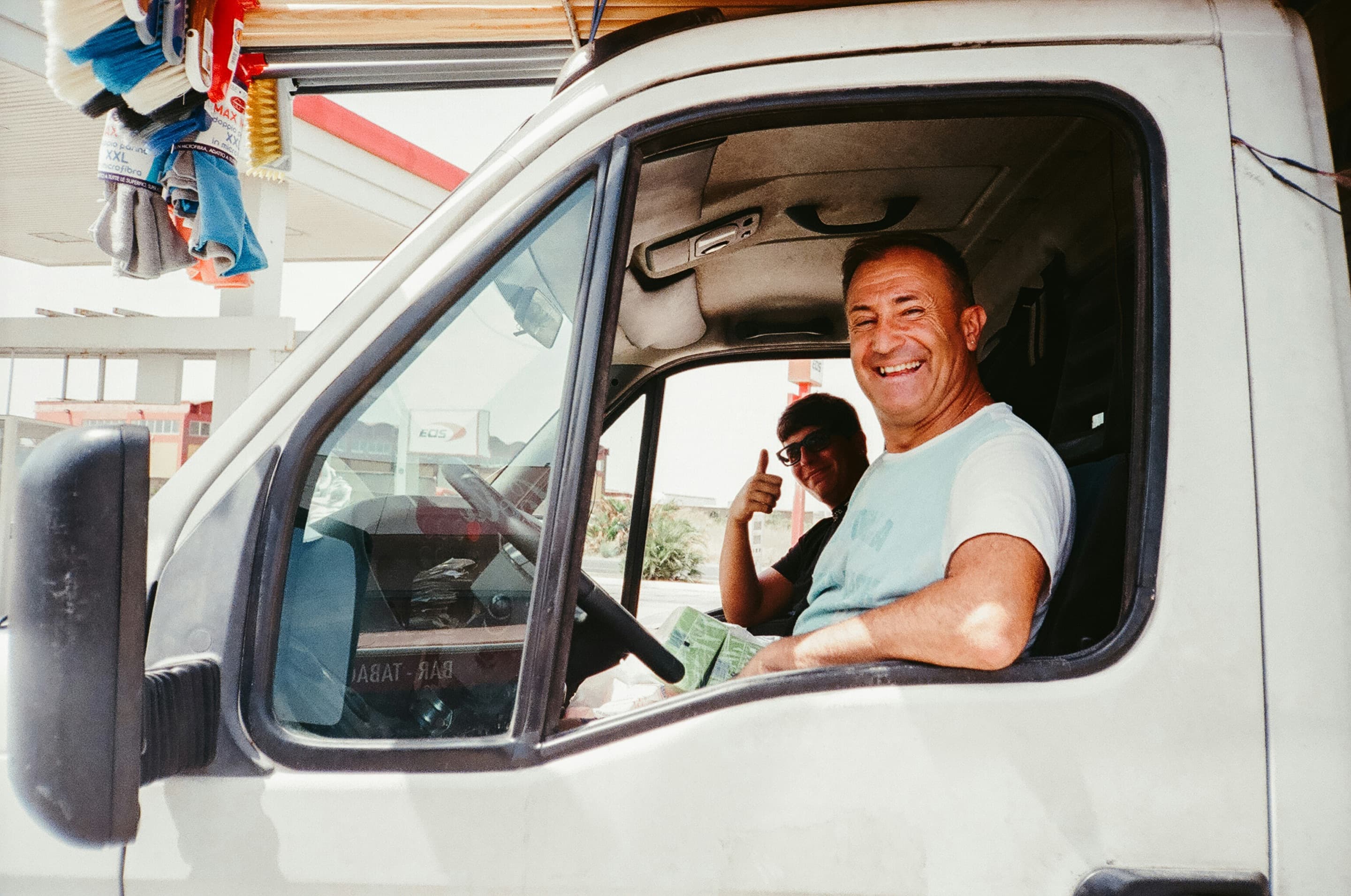 Motoristas sorrindo na cabine do caminhão
